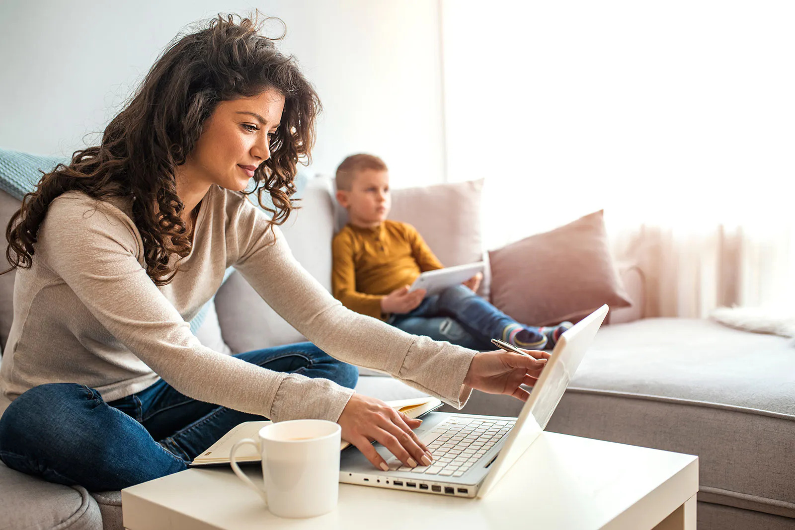 woman works remotely from her living room with her laptop