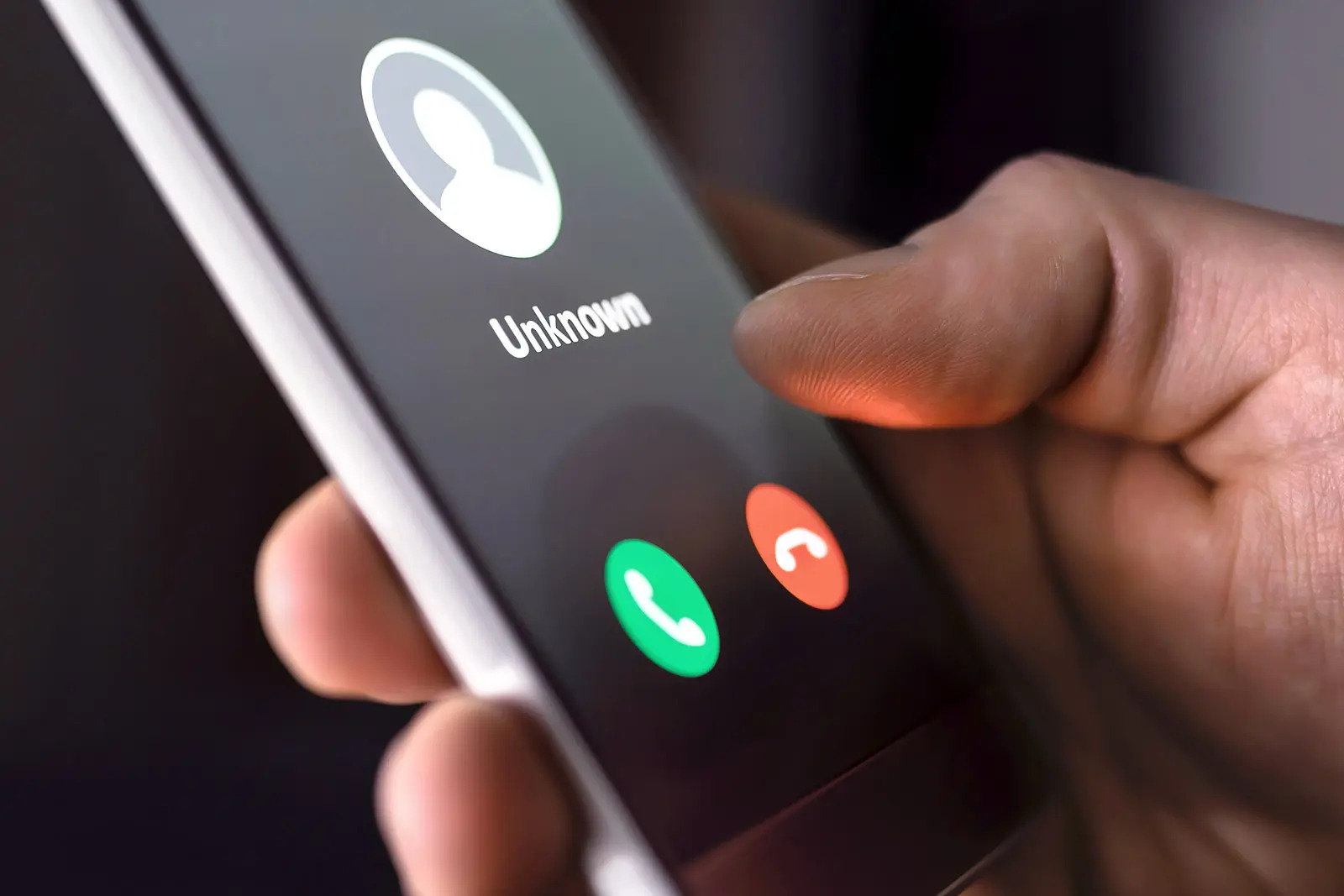 a person with a cell phone in hand receives a call from an unknown number.